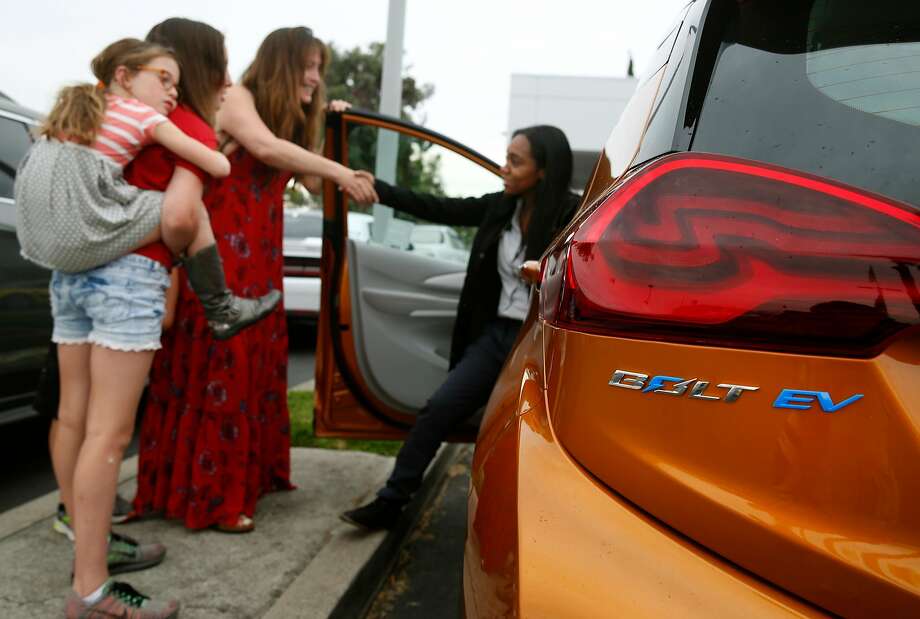 Sales associate Devani Knox (right) thanks Dana Nachman and her children  for test driving an all-electric Bolt at a Chevrolet dealership in Fremont. The Bolt topped electric car registrations in California last year, according to a new report. Photo: Paul Chinn, The Chronicle