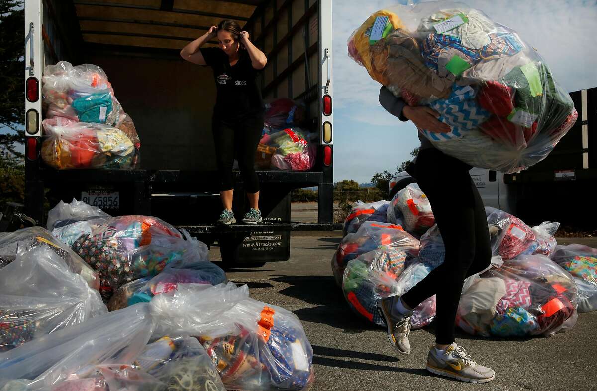 Julia Neff, right, of San Rafael City Schools takes a sack full of donated items from Becca Winslow with My New Red Shoes outside of the Sports Basement in the presidio August 2, 2017 in San Francisco, Calif. My New Red Shoes donated custom back-to-school packages to Hamilton Families and others to be given out to families right before the start of the school year.
