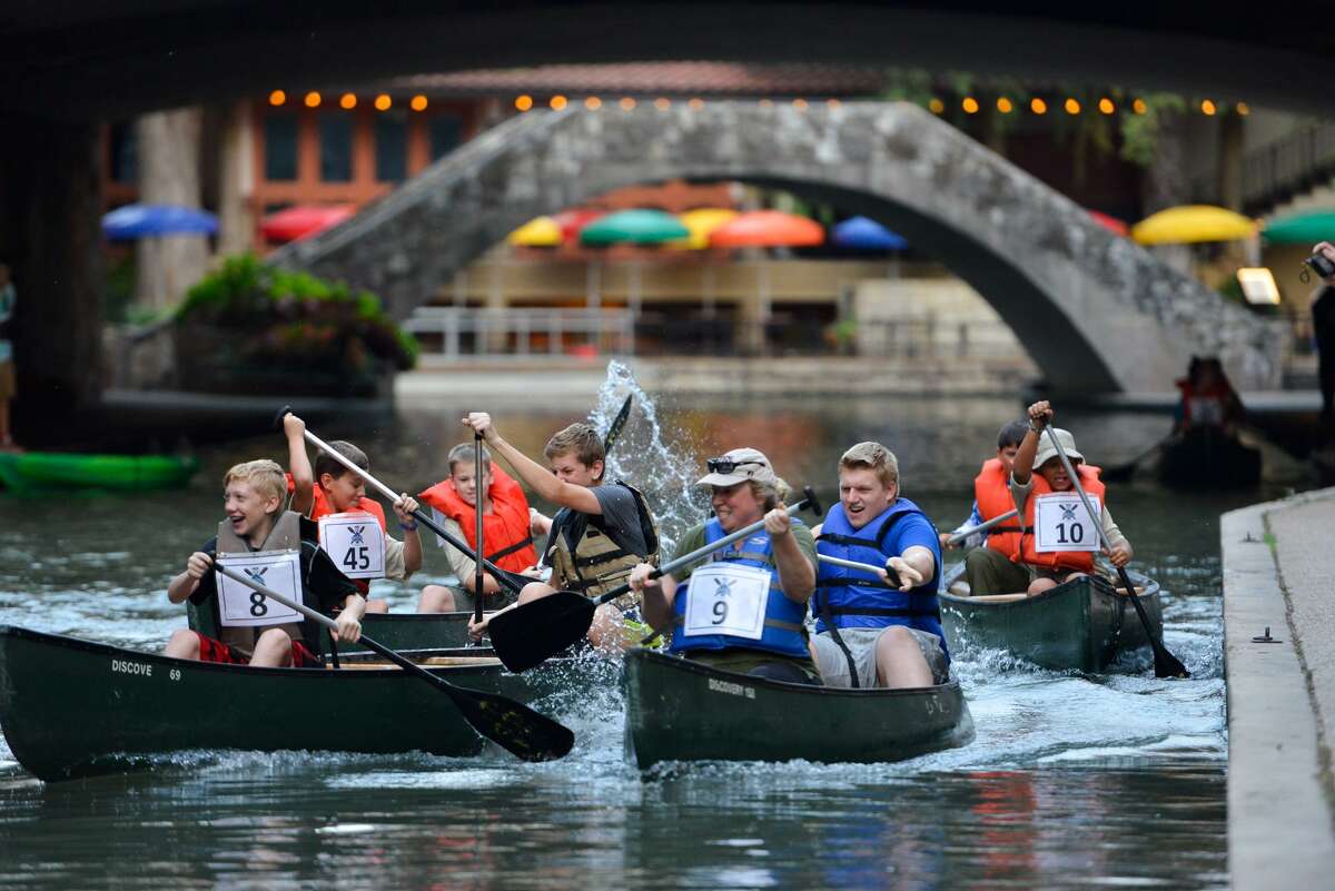 Scouts and their leaders paddle canoes along the San Antonio River during the Ford River Race.