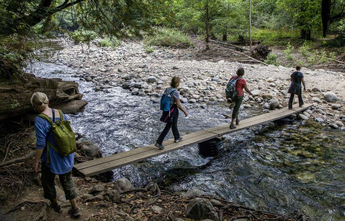 Hikers cross a footbridge on the Big Sur bypass trail that allows access to the area cut off by the Pfeiffer Canyon Bridge closure.