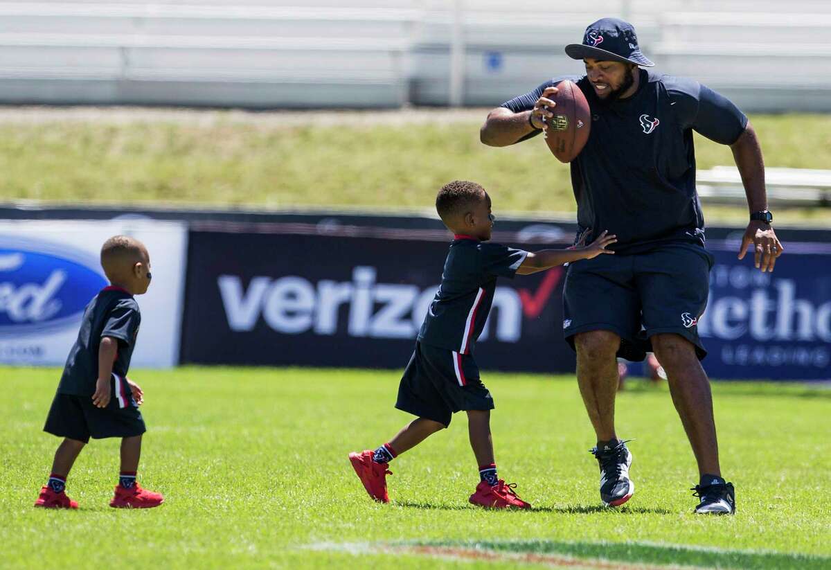 Houston Texans offensive tackle Chris Clark plays with his sons, Christian, 2, and C.J., 4, after training camp practice at the Greenbrier on Saturday, Aug. 5, 2017, in White Sulphur Springs, W.Va.