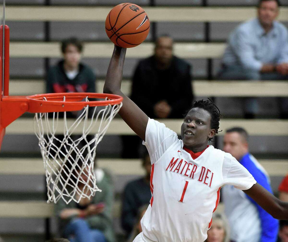 FILE - In this Feb. 4, 2017, file photo, Mater Dei's Bol Bol dunks against St. Augustine, in Santa Ana, Calif. Bol was among the top recruits who played in tournaments around Las Vegas the last week of July during the live recruiting period for college coaches. (Bill Alkofer/The Orange County Register via AP, File) 
