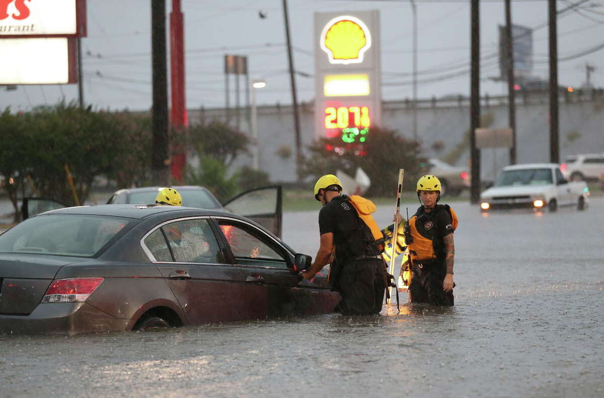 San Antonio Fire Department personnel check out vehicles stuck in high water at Marbach Road and Loop 410, Monday, August 7, 2017.