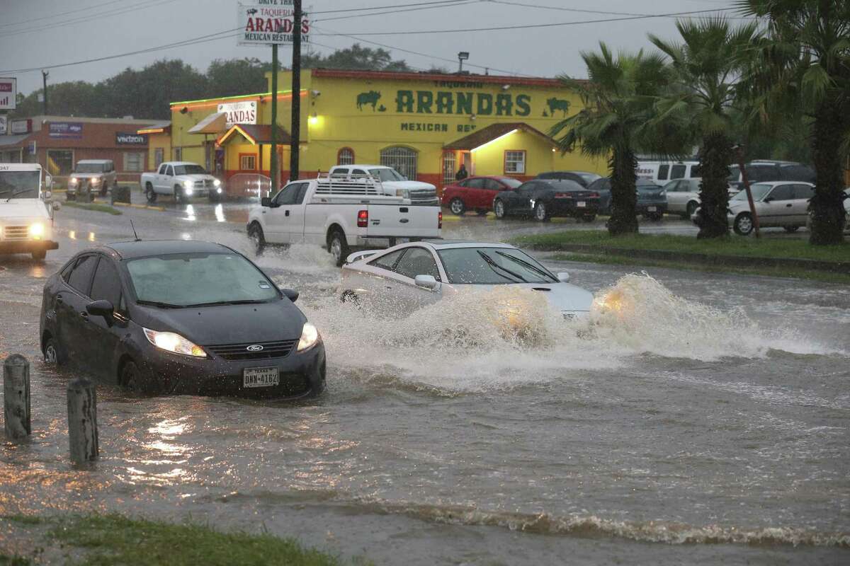Traffic moves around a vehicle stalled in high water at the intersection of West Military Drive and Westbriar, Monday, August 7, 2017.