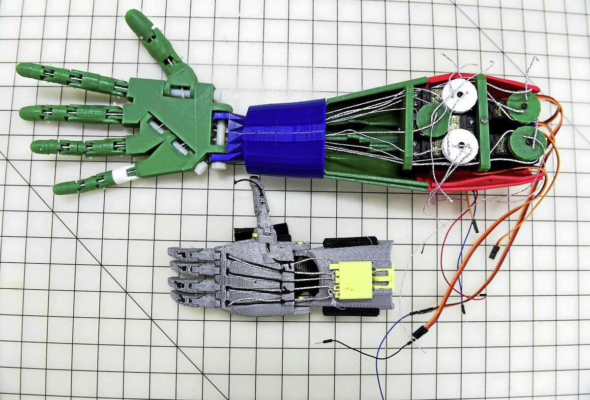 (Peter Hvizdak - New Haven Register)West Haven, Connecticut: May 7, 2017. Using a 3D printer, Bruce O'Donnell, 66, of Cheshire, Connecticut made a robotic prosthetic hand and arm prototype, top, and a functional mechanical prosthetic hand, below.