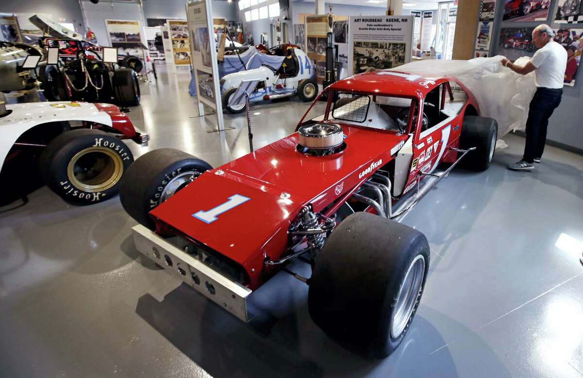 In this Wednesday, May 31, 2017 photograph, Dick Berggren, president of the North East Motor Sports Museum, uncovers the 1978 NASCAR-Modified race car driven by Geoff Bodine, at the museum in Loudon, N.H. The museum dedicated to motorsports in New England resides just outside the front gates the New Hampshire Motor Speedway. (AP Photo/Charles Krupa)
