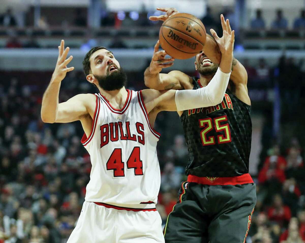 FILE - In this Wednesday, Jan. 25, 2017, file photo, Chicago Bulls forward Nikola Mirotic (44) fouls Atlanta Hawks forward Thabo Sefolosha (25) during the first half of an NBA basketball game in Chicago. Teams, and the league, try to make the transition to the NBA easier for all players, but internationals need some special attention. Mirotic said international players, even those from different countries, tend to stick together on the road. They go to movies and dinners together because they often have similar interests. (AP Photo/Kamil Krzaczynski, File)