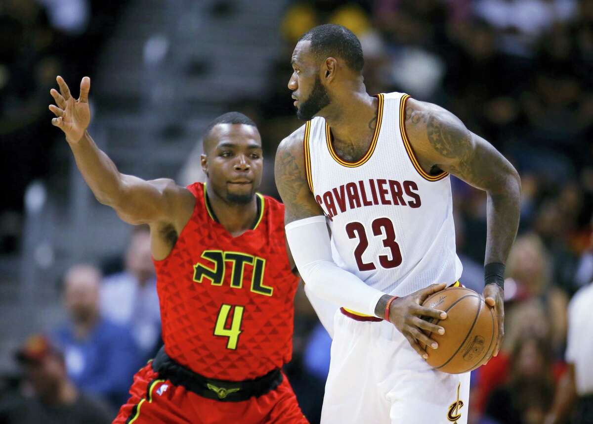Cleveland Cavaliers forward LeBron James (23) is defended by Atlanta Hawks forward Paul Millsap (4) in the first half of an NBA basketball game on Sunday, April 9, 2017, in Atlanta. The Hawks won in overtime 126-125. (AP Photo/Todd Kirkland)