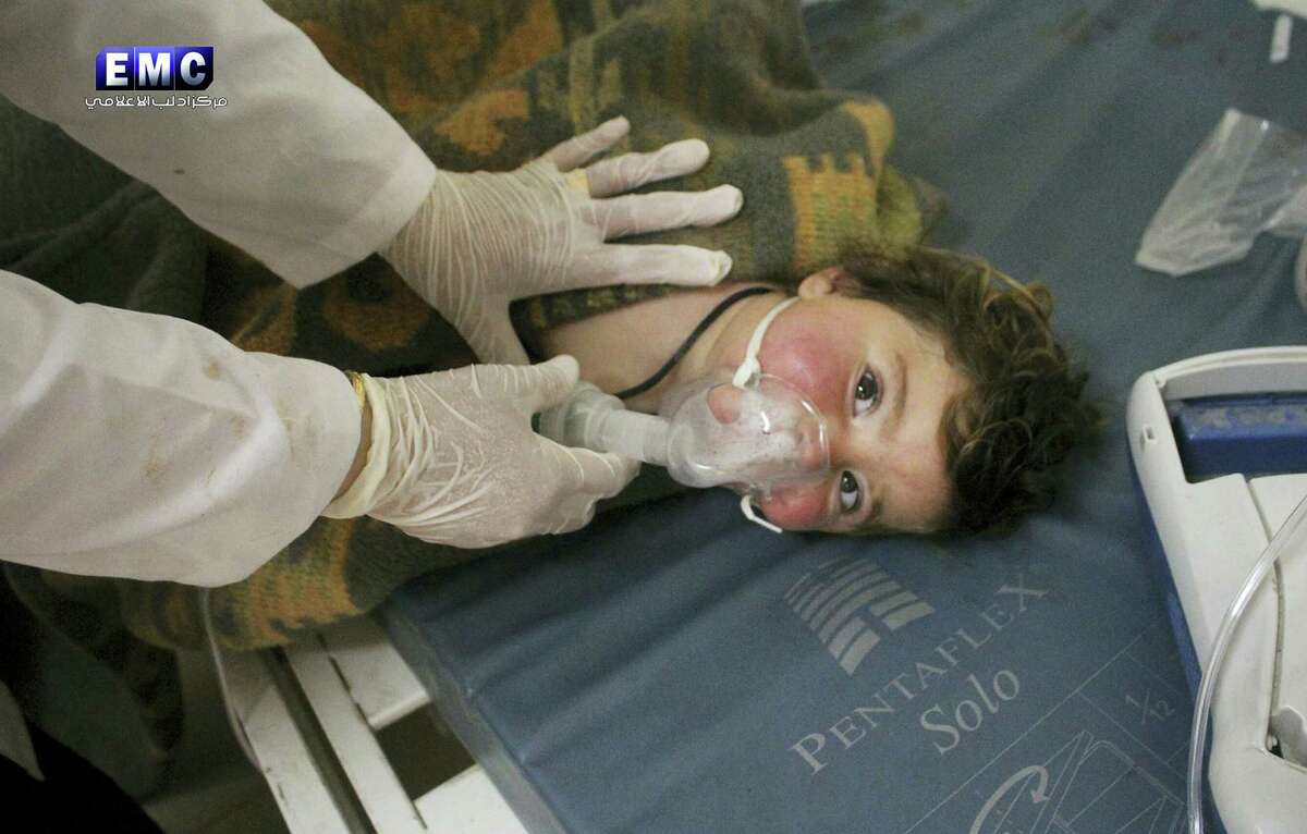 This photo provided by the Syrian anti-government activist group Edlib Media Center, which has been authenticated based on its contents and other AP reporting, shows a Syrian doctor treating a child following a suspected chemical attack, at a makeshift hospital, in the town of Khan Sheikhoun, northern Idlib province, Syria. The suspected chemical attack killed dozens of people on Tuesday, Syrian opposition activists said, describing the attack as among the worst in the country's six-year civil war. (Edlib Media Center, via AP)