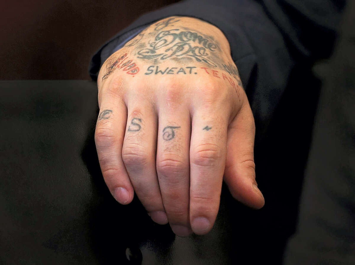 FILE- In this Oct. 13, 2015, file pool photo, tattoos cover the right hand of former New England Patriots football player Aaron Hernandez, as he attends a pre-trial hearing at Suffolk Superior Court in Boston. Body art has played a role in a surprising number of criminal cases nationwide, though legal experts concede that tattoos by themselves are rarely a deciding factor in convictions. (David L Ryan/The Boston Globe via AP, Pool, File)