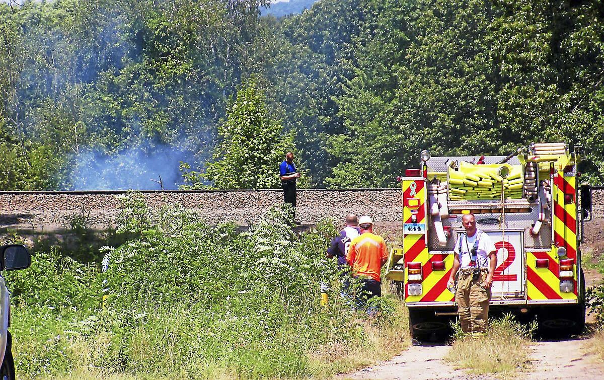 (Wes Duplantier/The New Haven Register)Firefighters from North Haven and Hamden worked for more than an hour Monday to contain a brush fire along the railroad tracks near part of Washington Avenue in North Haven.