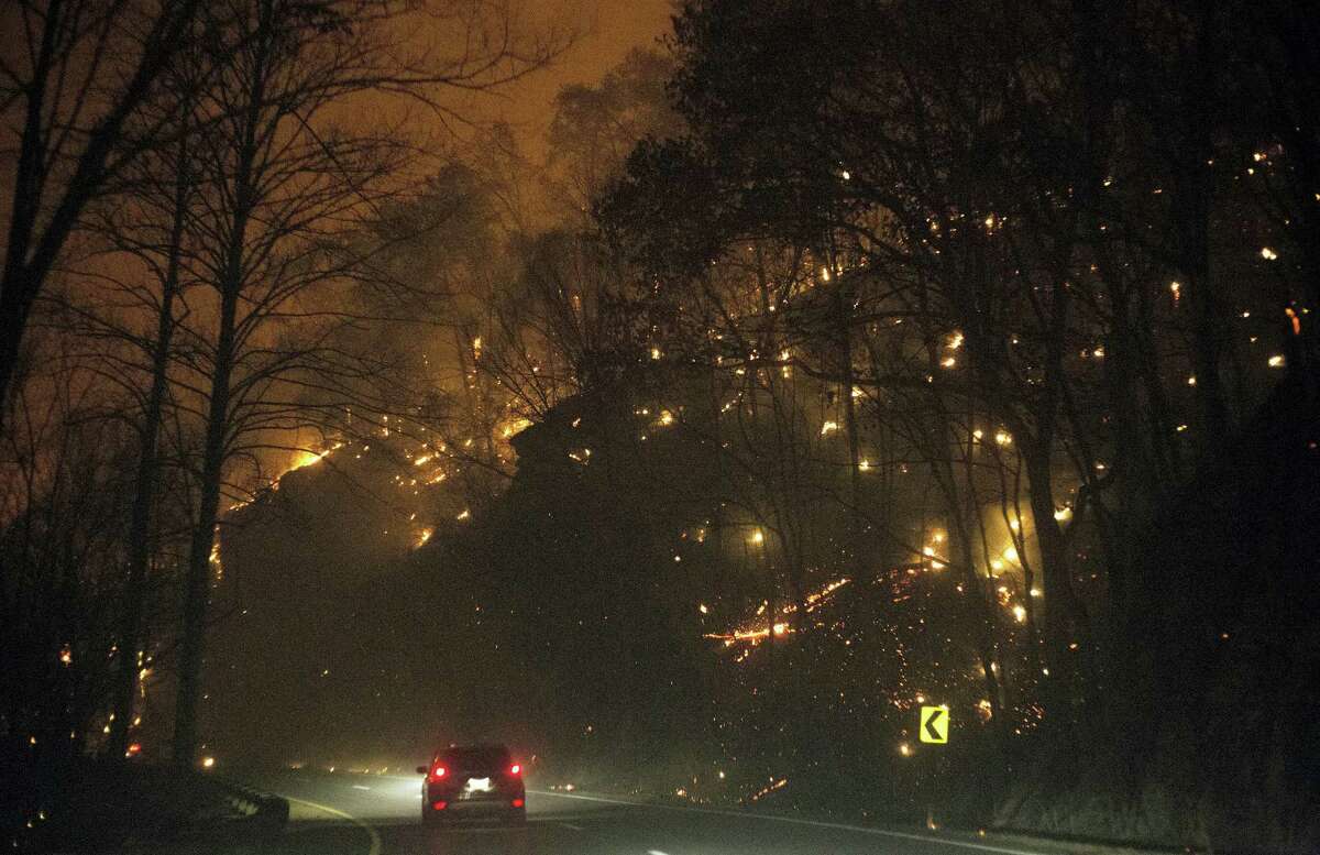 Fire erupts on both side of Highway 441 between Gatlinburg and Pigeon Forge, Tenn., Monday, Nov. 28, 2016. In Gatlinburg, smoke and fire caused the mandatory evacuation of downtown and surrounding areas, according to the Tennessee Emergency Management Agency. (Jessica Tezak/Knoxville News Sentinel via AP)