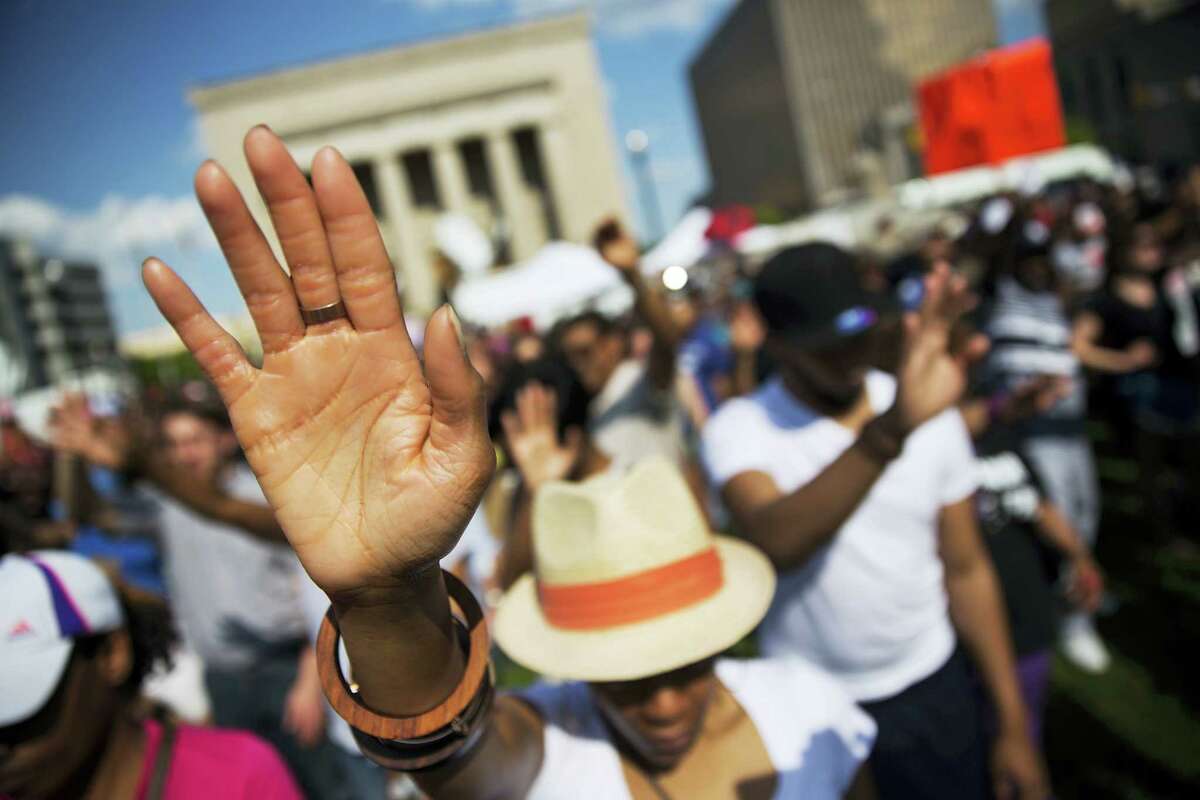 FILE - In this May 3, 2015 file photo, people pray during a rally at City Hall in Baltimore, where hundreds of jubilant people prayed and chanted for justice days after the city's top prosecutor charged six officers involved in Freddie Gray's arrest. Since Gray's death, several community groups have emerged, particularly in West Baltimore, and community activism, advocacy and grassroots organizing are more visible throughout the city. (AP Photo/David Goldman, File)