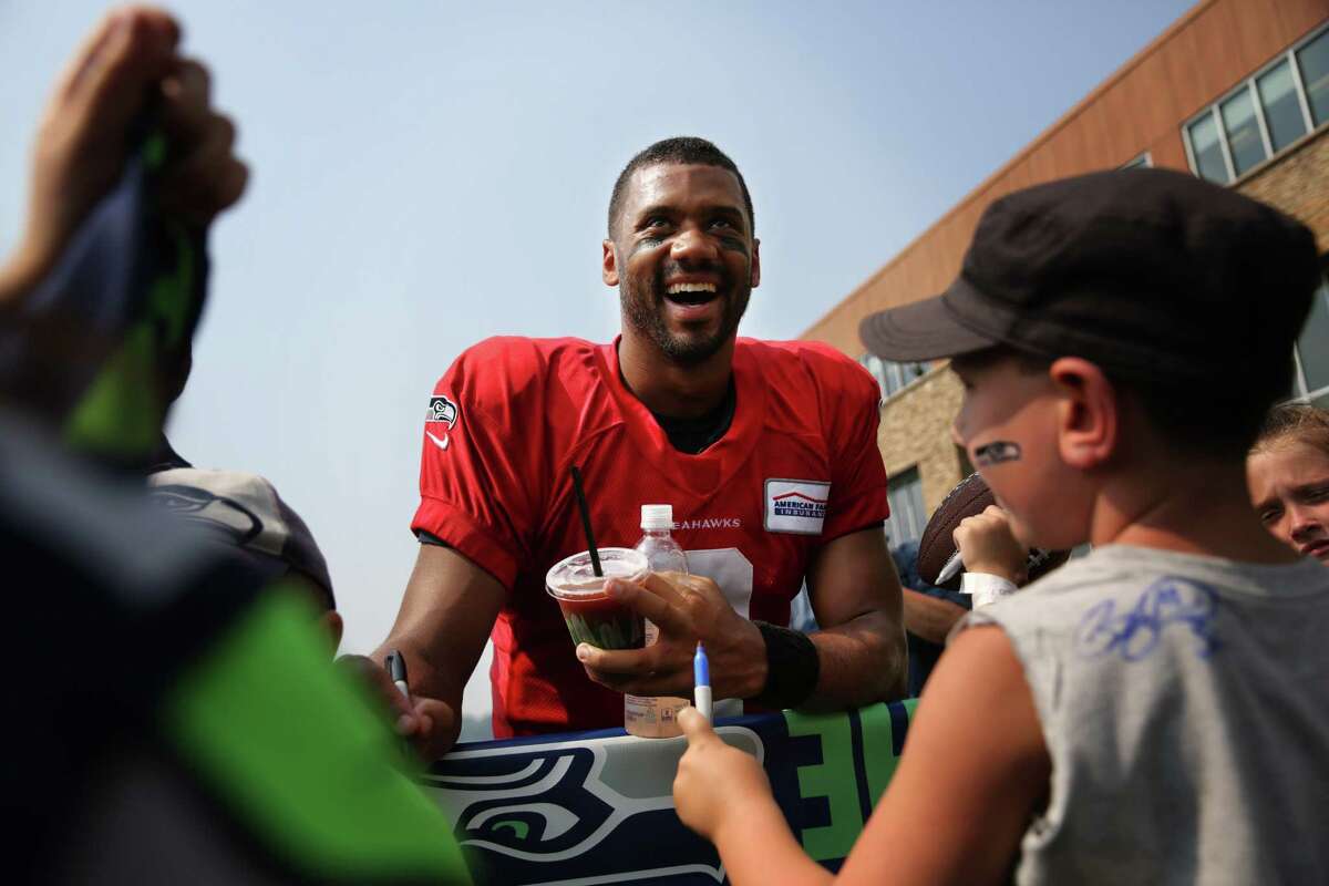 Russell Wilson signs autographs after Seahawks training camp, Monday, Aug. 7, 2017.