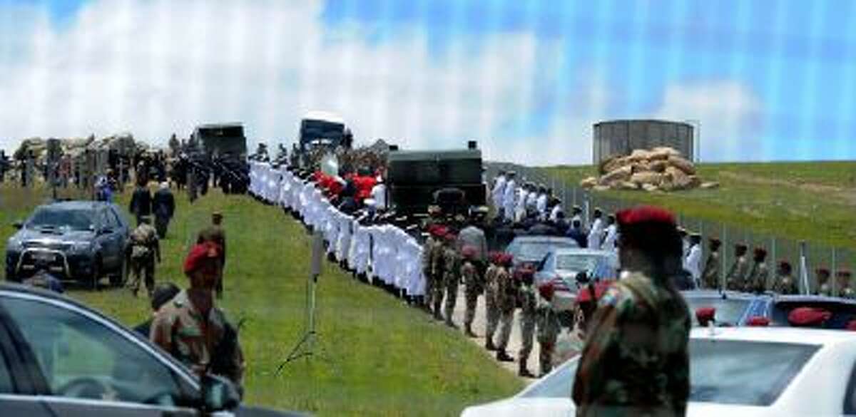 Former South African President Nelson Mandela's casket is taken by military gun carriage to his burial place following his funeral service in Qunu, South Africa, Sunday, Dec. 15, 2013.