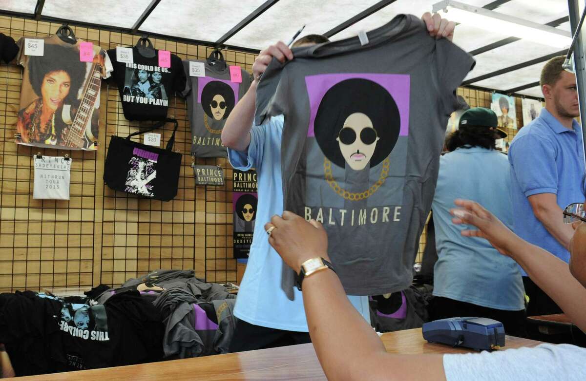 Karen Howard of Washington, DC purchases a t-shirt prior to Prince's Baltimore concert Sunday, May 10, 2015. (Jerry Jackson/The Baltimore Sun via AP)