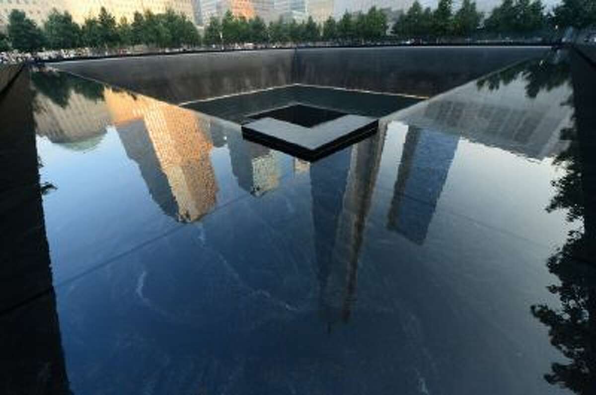 This Sept. 11, 2013 file photo shows One World Trade Center, center, is reflected on the polished wall of the September 11 Memorial on the 12th anniversary of the terrorist attacks on the World Trade Center in New York.