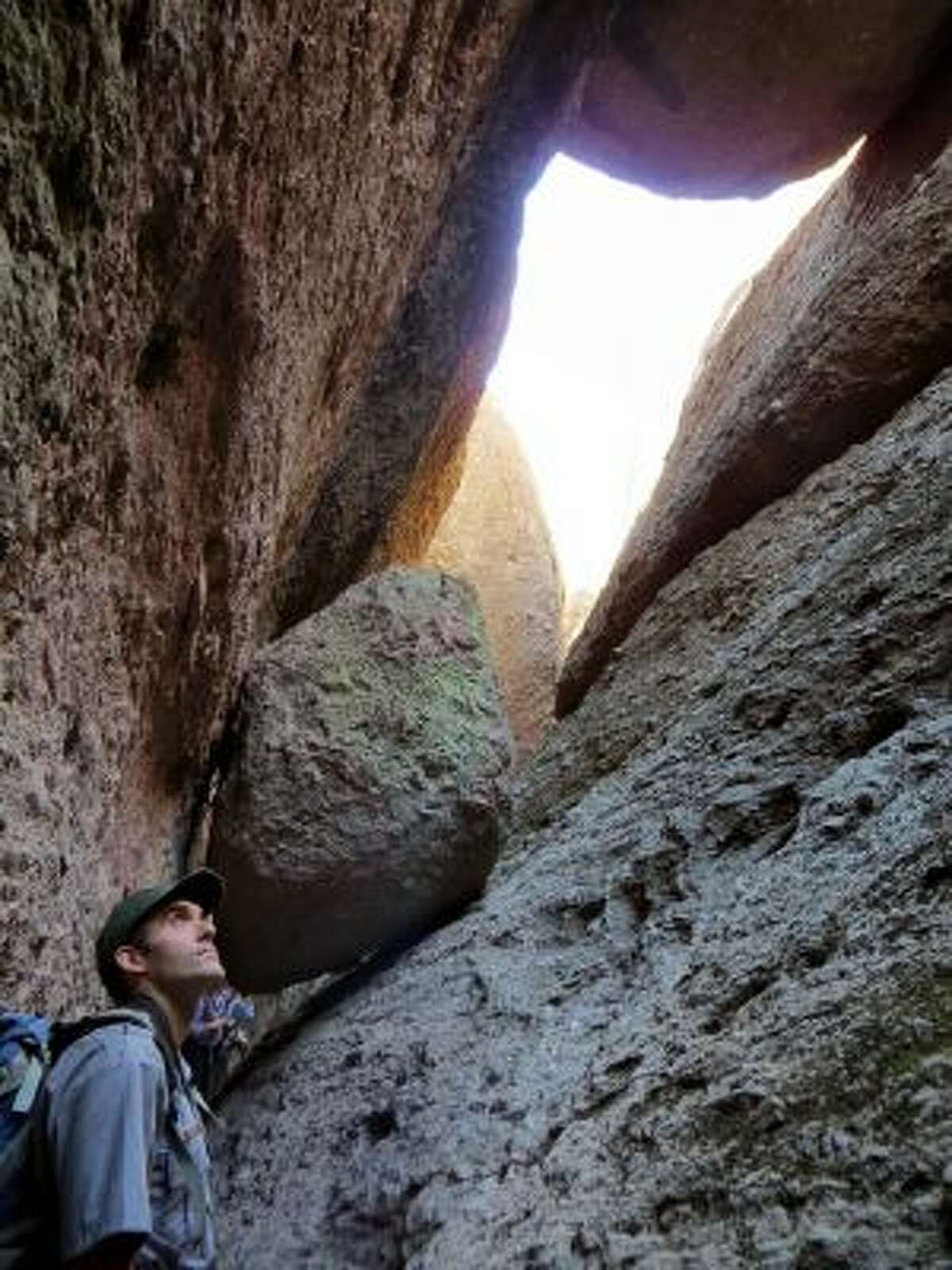 Boulders flank this entrance to Balconies Cave, formed when massive fallen rock, called talus, wedged into the tops of narrow gorges. Wildlife biologist Gavin Emmons leads the way into the pitch-black cave, which requires use of flashlights.
