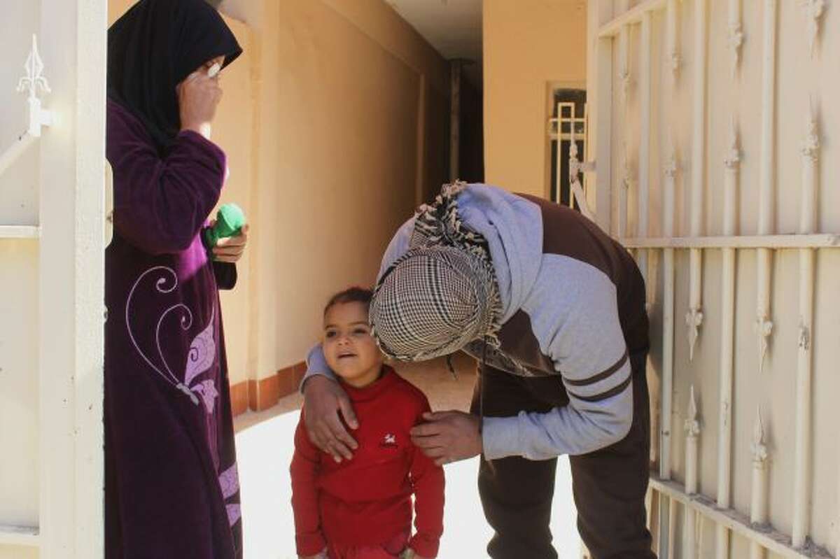 In this Feb. 11, 2014, a masked anti-government gunman talks to his neighbors in Fallujah, Iraq. Islamic militants who took over the Iraqi city of Fallujah are now trying to show they can run it, providing social services, policing the streets and implementing Shariah rulings in a bid to win the support of its Sunni Muslim population. (AP Photo)