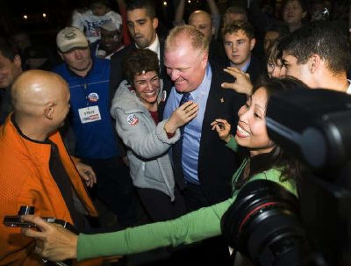 In this Monday, Oct. 25, 2010 photo, Toronto Mayor-elect Rob Ford, center, is greeted by a mob of supporters as he arrives to speak to supporters in Toronto.