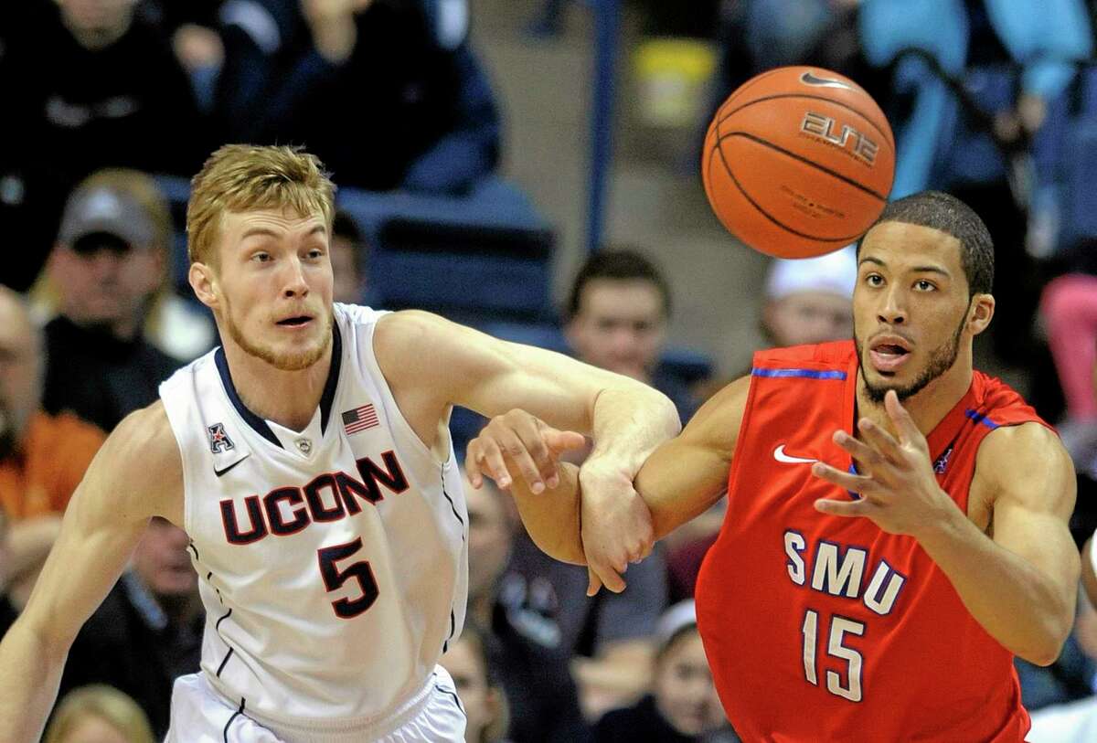 Connecticut’s Niels Giffey (5) and SMU’s Cannen Cunningham (15) fight for the loose ball during the first half in Storrs on Sunday.