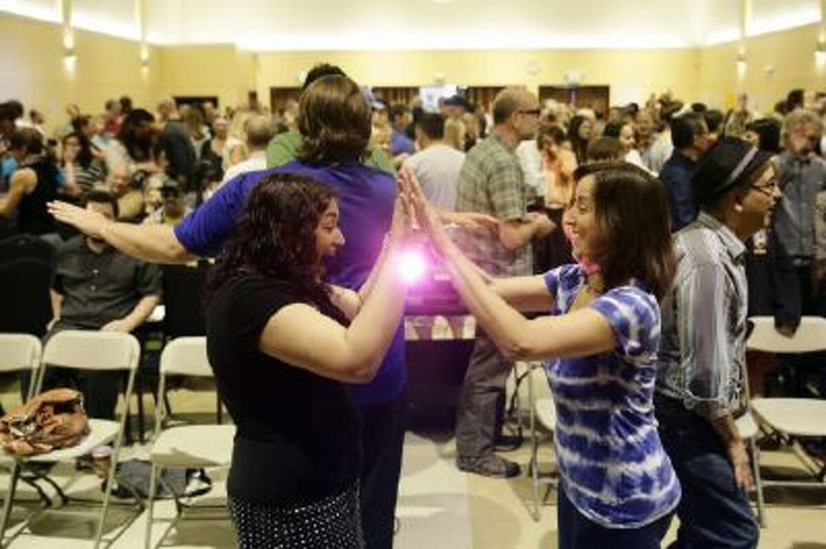 Attendees play a game with each other at the Sunday Assembly, a godless congregation founded by British comedians Sanderson Jones and Pippa Evans, on Sunday, Nov. 10, 2013, in Los Angeles.