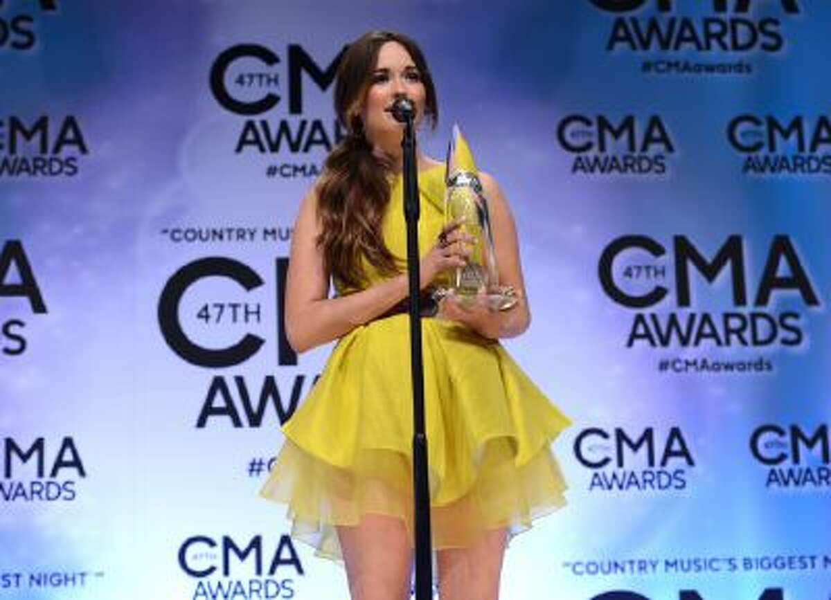 Kacey Musgraves poses backstage with the award for new artist of the year at the 47th annual CMA Awards at Bridgestone Arena on Wednesday, Nov. 6, 2013, in Nashville, Tenn.
