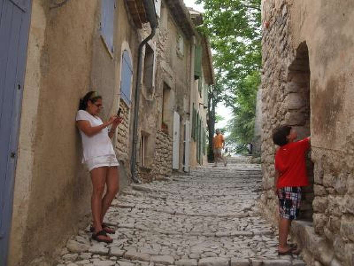 The streets of Banon, France, shown on July 14, turn into tiny passageways as they climb to the ruins of a 12th century castle. Here Diego Niiler examines a tiny doorway cut into the stone walls.
