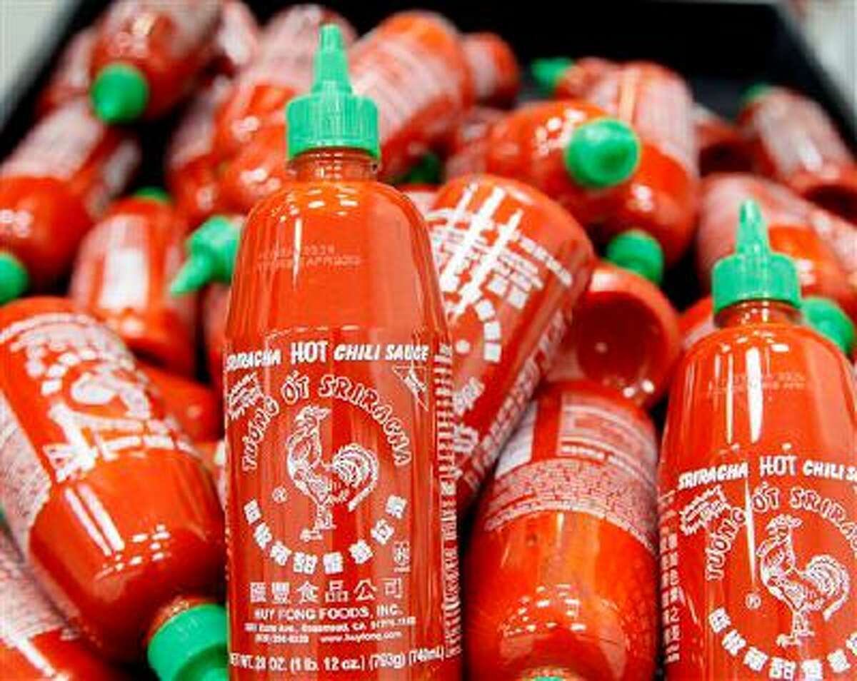Sriracha chili sauce bottles are produced at the Huy Fong Foods factory in Irwindale, Calif., on Tuesday, Oct 29, 2013. The maker of Sriracha hot sauce is under fire for allegedly fouling the air around its Southern California production site. The city of Irwindale filed a lawsuit in Los Angeles Superior Court Monday asking a judge to stop production at the Huy Fong Foods factory, claiming the chili odor emanating from the facility is a public nuisance. (AP Photo/Nick Ut)