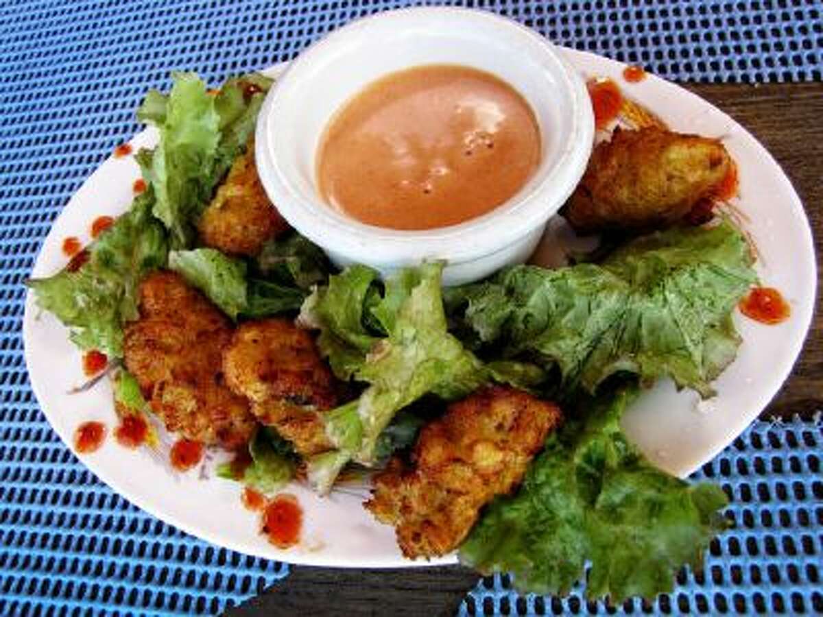 Conch fritters with a side of special hot sauce is served at the popular beachfront hangout, Sunshine's Beach Bar and Grill in Nevis.
