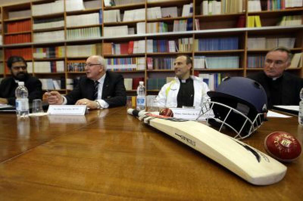 From left, Father Theodore Mascarenhas, Australian Ambassador to the Holy See John McCarthy, Monsignor Sanchez de Toca y Alameda, undersecretary of the Pontifical Council for Culture, and Father Eamon O' Higgins meet the journalists as cricket equipment is displayed on a table at the Vatican on Oct. 22,.