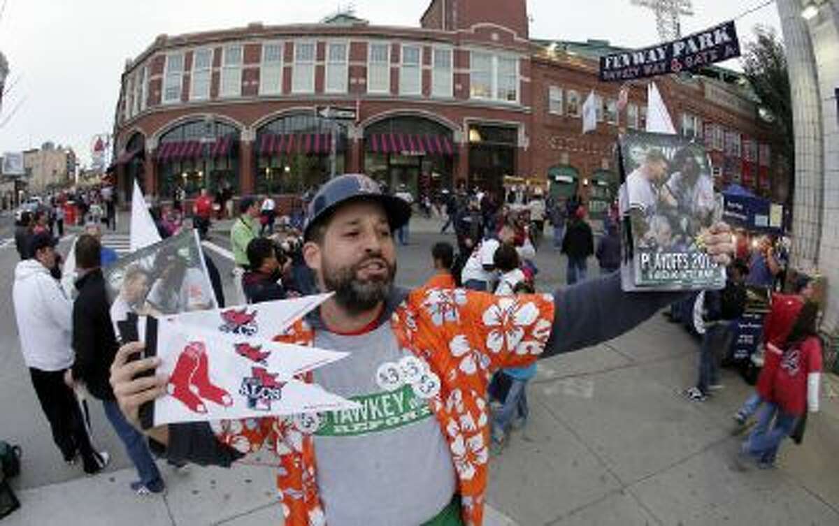 Tim Lampa hawks programs and Boston Red Sox pennants outside Fenway Park before Game 6 of the American League Championship Series between the Red Sox and the Detroit Tigers.