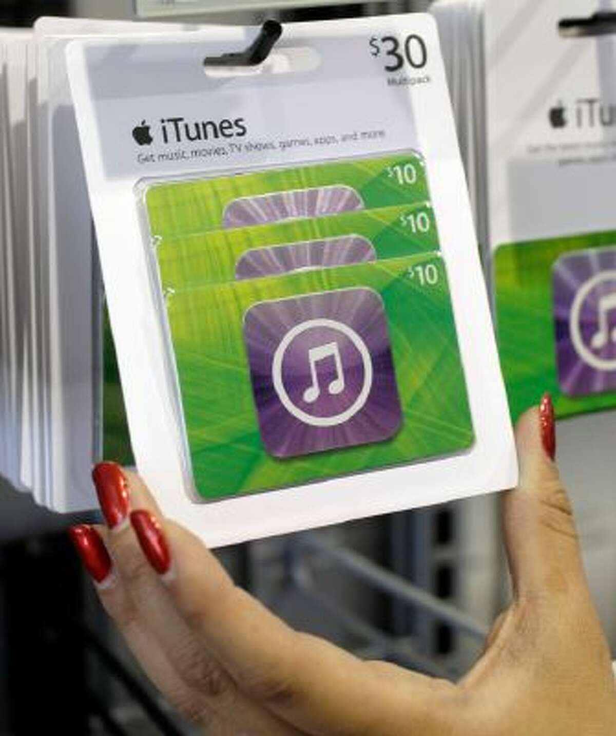 Customer picks up an Apple iTunes gift card on display at a Best Buy in Mountain View, Calif.