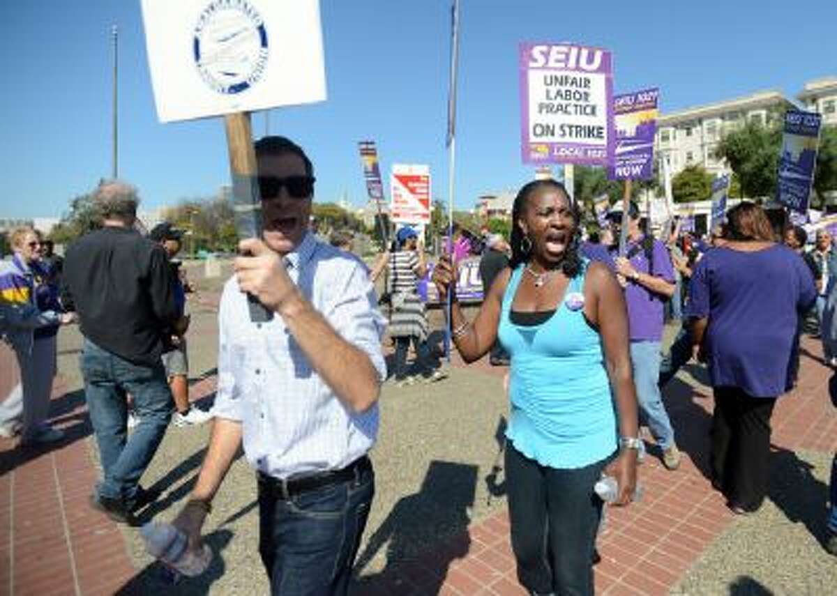 Union members walk the picket line during a noontime rally outside of the Lake Merritt BART station in Oakland, Calif., on Friday, Oct. 18, 2013.
