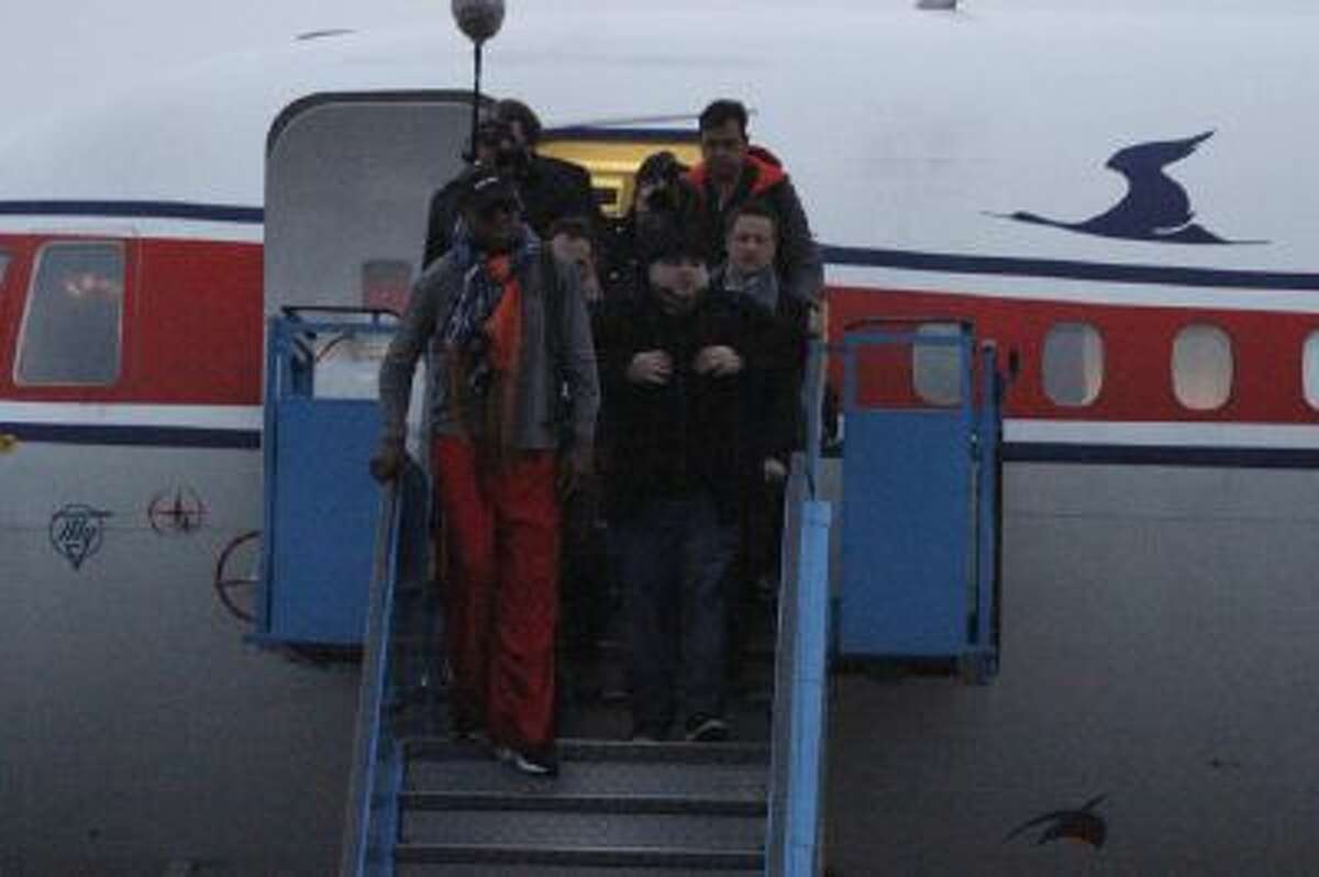 Former NBA basketball star Dennis Rodman disembarks from a North Korean Air Koryo flight from Beijing as he and his entourage arrive at the international airport in Pyongyang, North Korea on Thursday, Dec. 19, 2013.