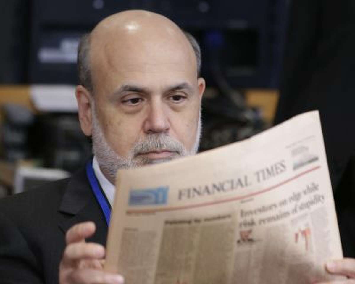 Ben Bernanke, chairman of the Federal Reserve, reads a newspaper before a meeting of the IMFC, during the World Bank/IMF Annual Meetings at IMF headquarters, Saturday, Oct. 12, 2013, in Washington.