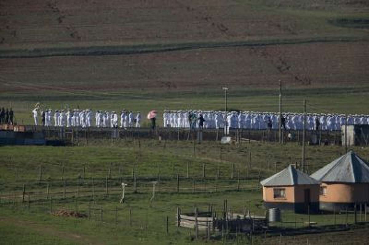 Members of the South African navy line the road from the Mandela family house to his burial site prior to the burial of former South African President Nelson Mandela in his hometown Qunu, South Africa, Sunday Dec. 15, 2013.