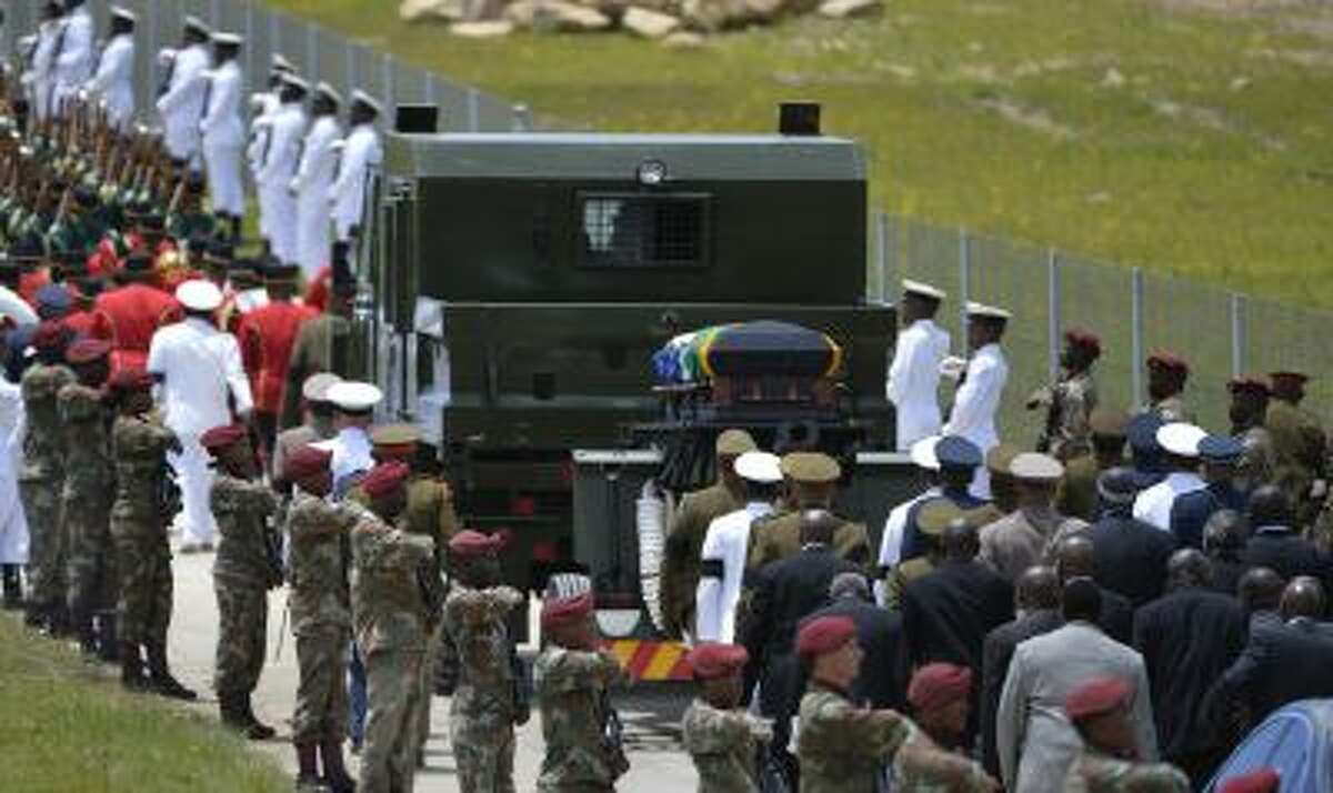 Former South African President Nelson Mandela's casket is take by military gun carriage to his burial place following his funeral service in Qunu, South Africa, Sunday, Dec. 15, 2013.