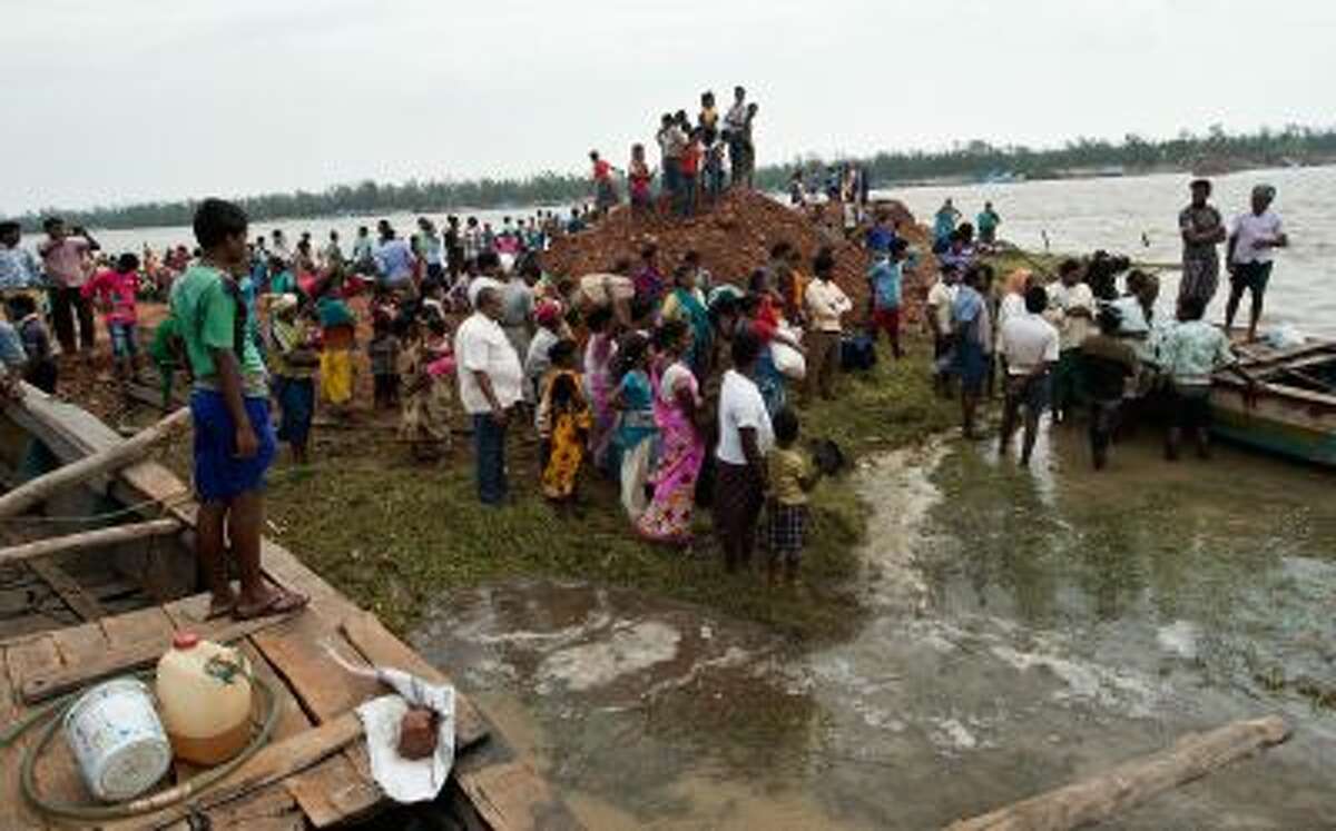 Displaced villagers wait for a boat at Sonepur village around 15kms from Gopalpur on October 13, 2013 after cyclone Phailin passed through.