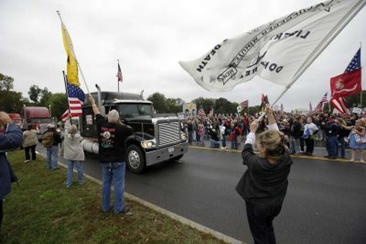 Protesters cheer as large trucks arrive at a rally at the World War II Memorial on the National Mall in Washington Sunday, Oct. 13, 2013.
