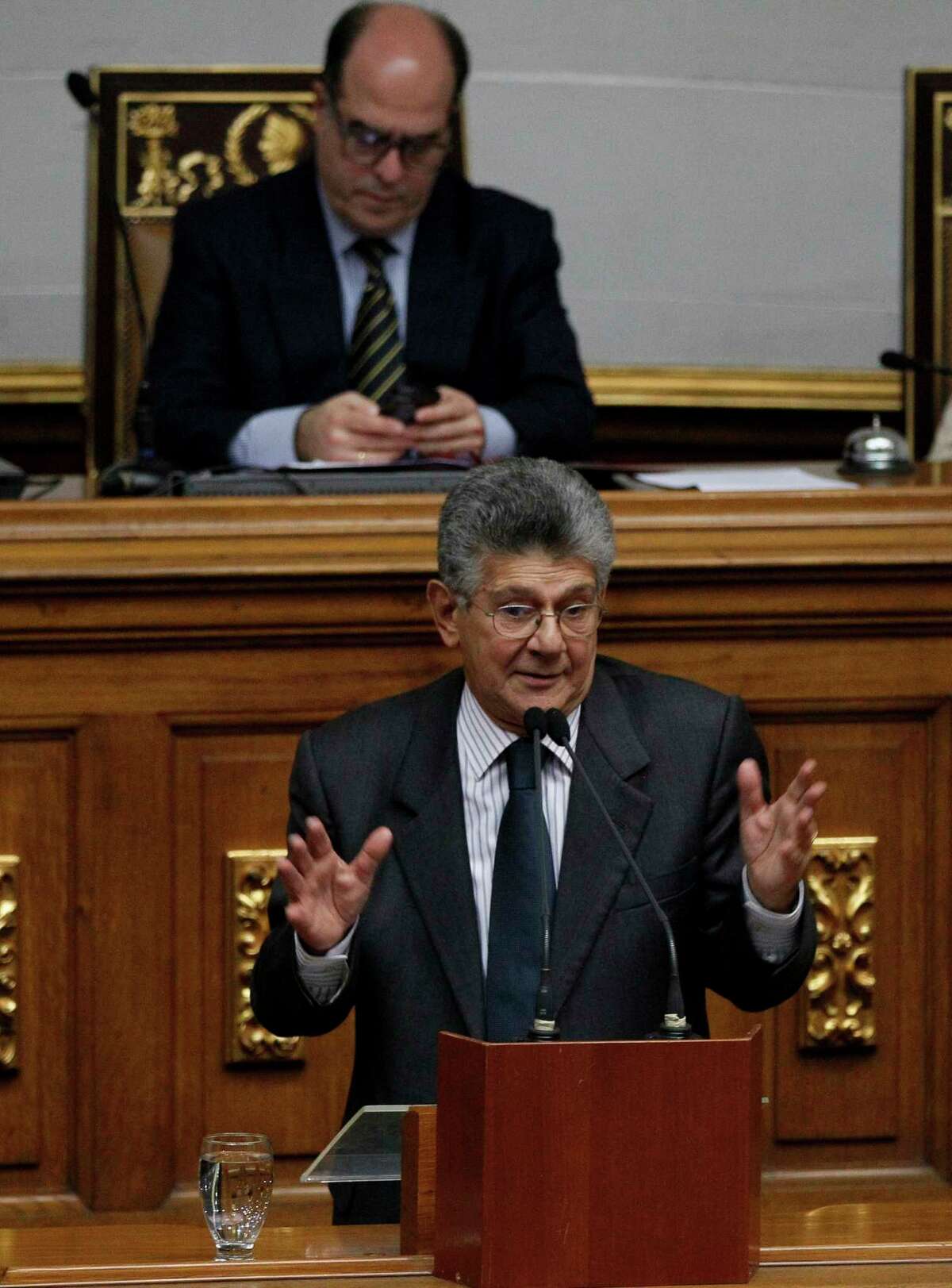 Opposition lawmaker Henry Ramos Allup speaks during a session of the National Assembly in Caracas, Venezuela, Monday, Aug. 7, 2017. The opposition-controlled National Assembly vowed to continue meeting at the stately legislative palace - a short walk across a plaza from where the all-powerful Constitutional Assembly is expected to hold its next meeting Tuesday. National Assembly President Julio Borges, pictured in background, told fellow lawmakers they should keep an active presence in the building despite threats from the new assembly to swiftly strip them of any authority and lock up key leaders. (AP Photo/Ariana Cubillos) ORG XMIT: XFLL104