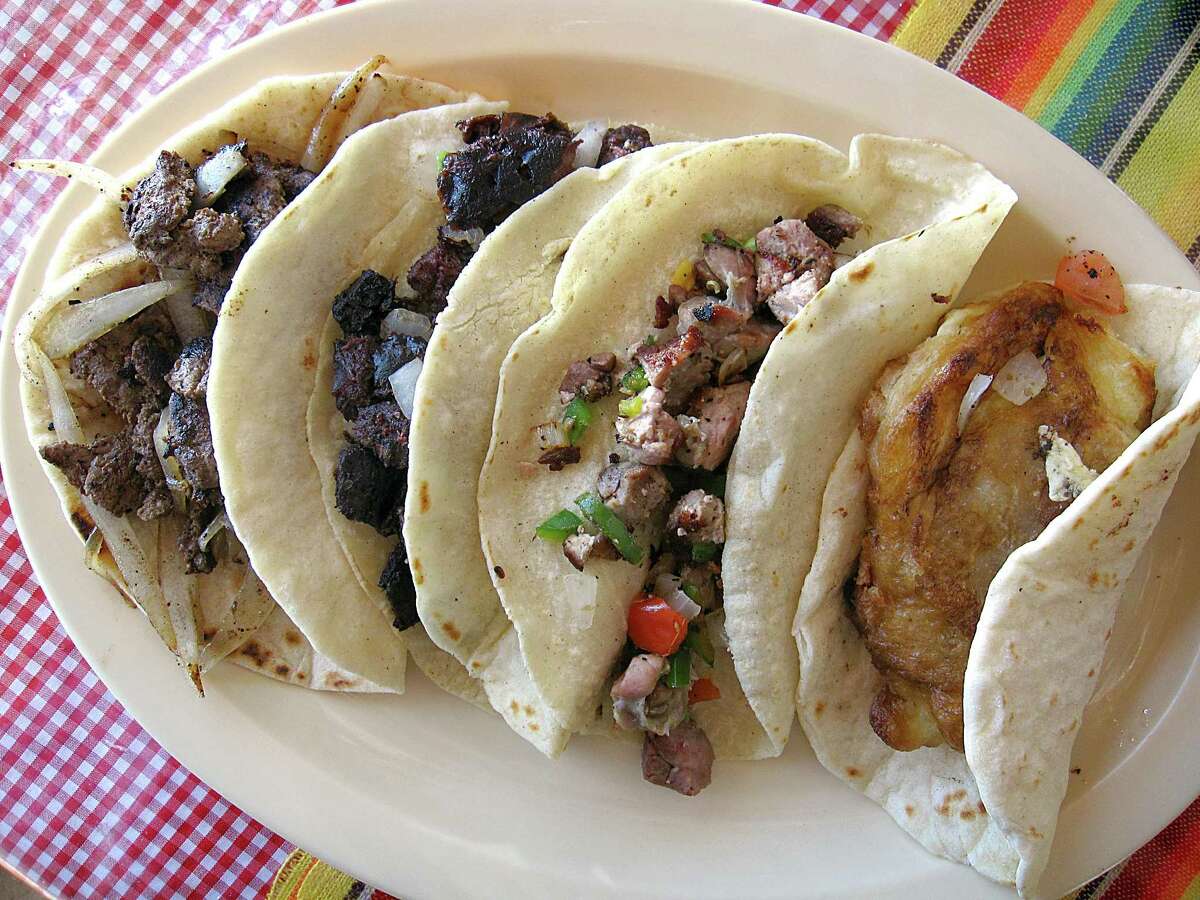 From left: a liver and onions taco on a handmade flour tortilla, a morcilla taco a la mexicana taco and a mollejas a la mexicana taco on handmade corn and a pata de puerco lampreada taco on handmade flour from Rossy's Tacos.