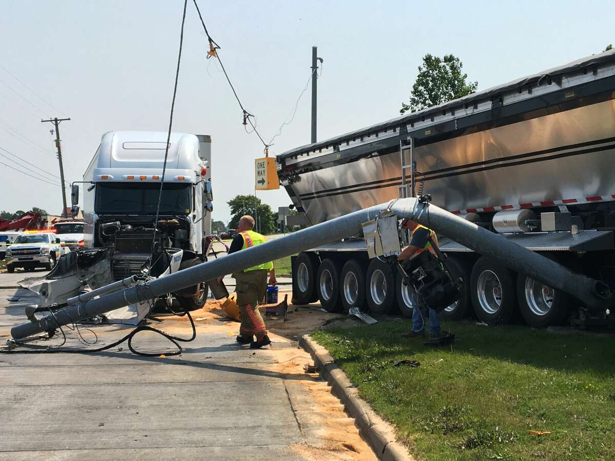 A downed traffic pole lies on the ground near two tractor-trailers after they collided while driving northbound on Washington Street, causing one to knock down the traffic light, at the intersection of Washington and Patrick on Tuesday.