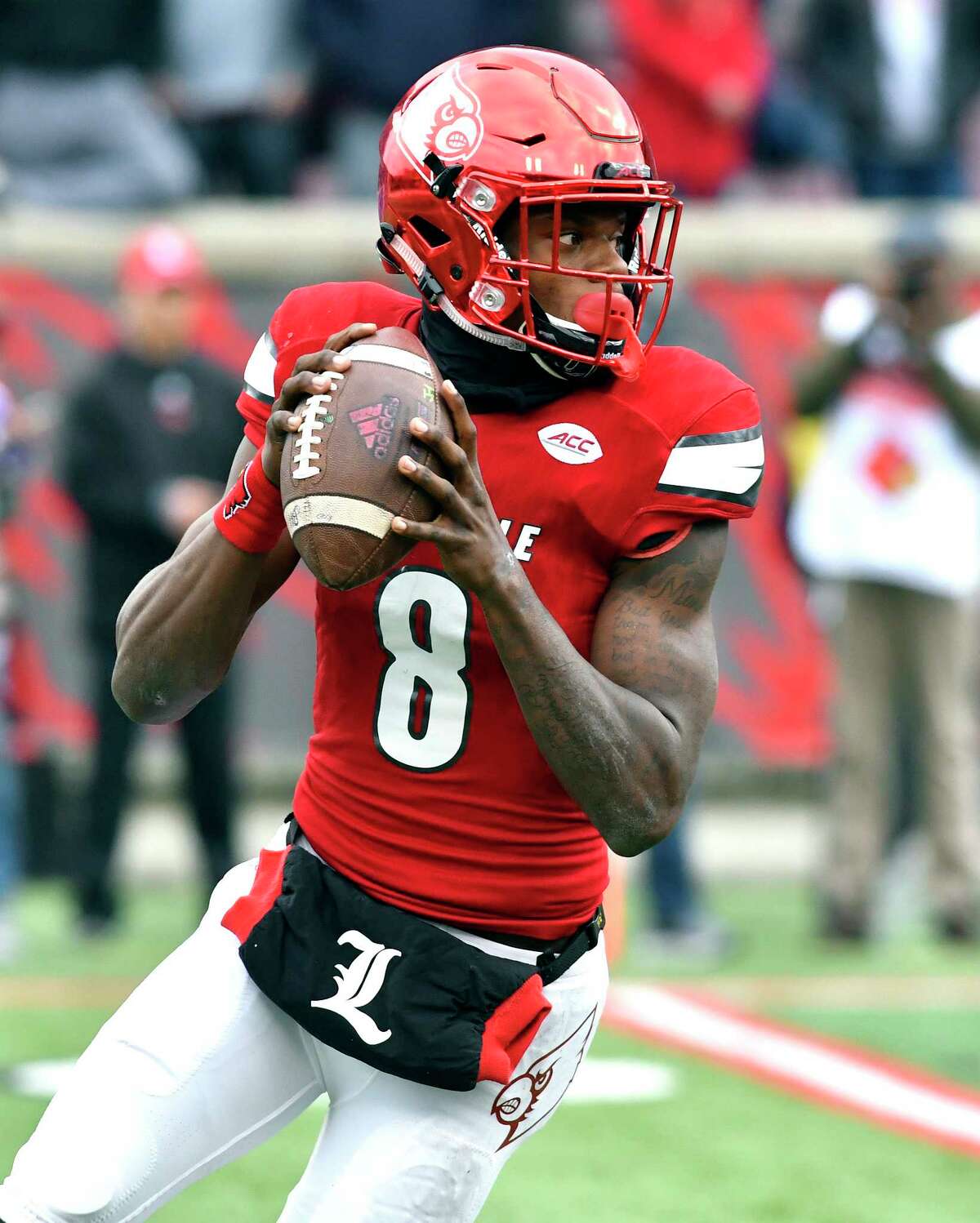 FILE- In this Nov. 26, 2016, file photo, Louisville's Lamar Jackson (8) looks for an open receiver during the first half of an NCAA college football game against Kentucky in Louisville, Ky. Jackson won the Heisman Trophy last year and has a chance to become only the second two-time winner of the award. (AP Photo/Timothy D. Easley, File)