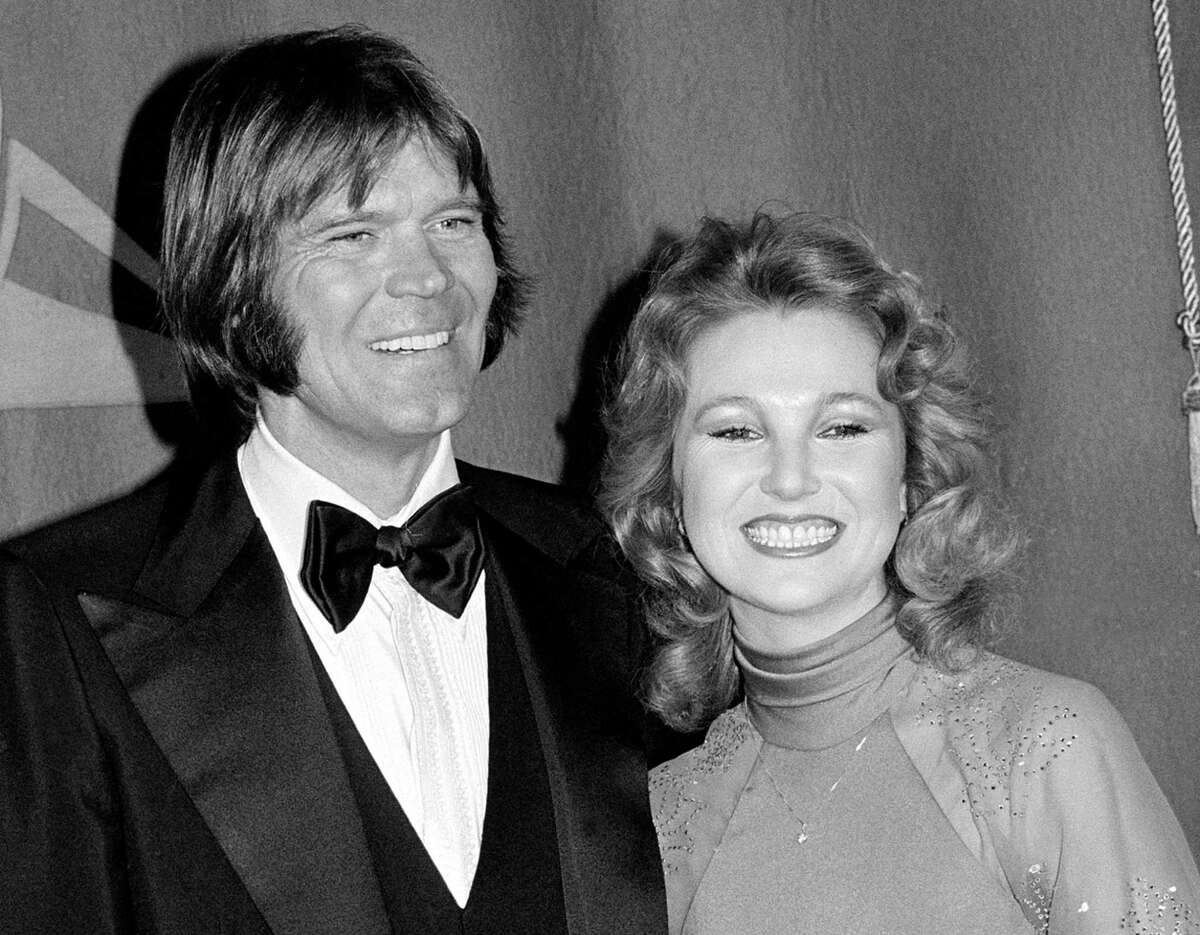 FILE - In this Feb. 15, 1979 file photo, country singers Glen Campbell, left, and Tanya Tucker, engaged to one another, are shown at the Grammy Awards in Los Angeles. Campbell, the grinning, high-pitched entertainer who had such hits as "Rhinestone Cowboy" and spanned country, pop, television and movies, died Tuesday, Aug. 8, 2017. He was 81. Campbell announced in June 2011 that he had been diagnosed with Alzheimer's disease. (AP Photo, File)