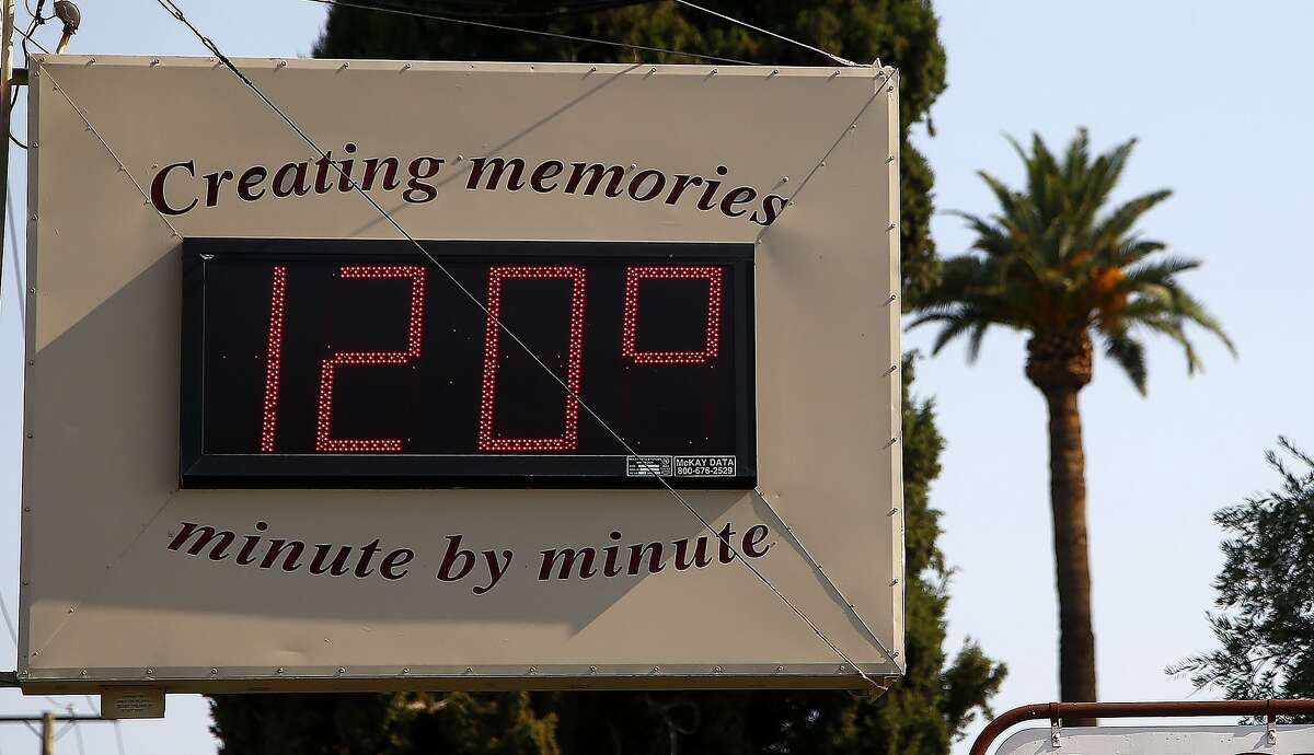 FILE - In this June 20, 2017, file photo, a local temperature sign reads 120-degrees as temperatures climb to near-record highs in Phoenix. As President Donald Trump touts new oil pipelines and pledges to revive the nation�s struggling coal mines, federal scientists are warning that burning fossil fuels is already driving a steep increase in the United States of heat waves, droughts and floods. (AP Photo/Ross D. Franklin, File)