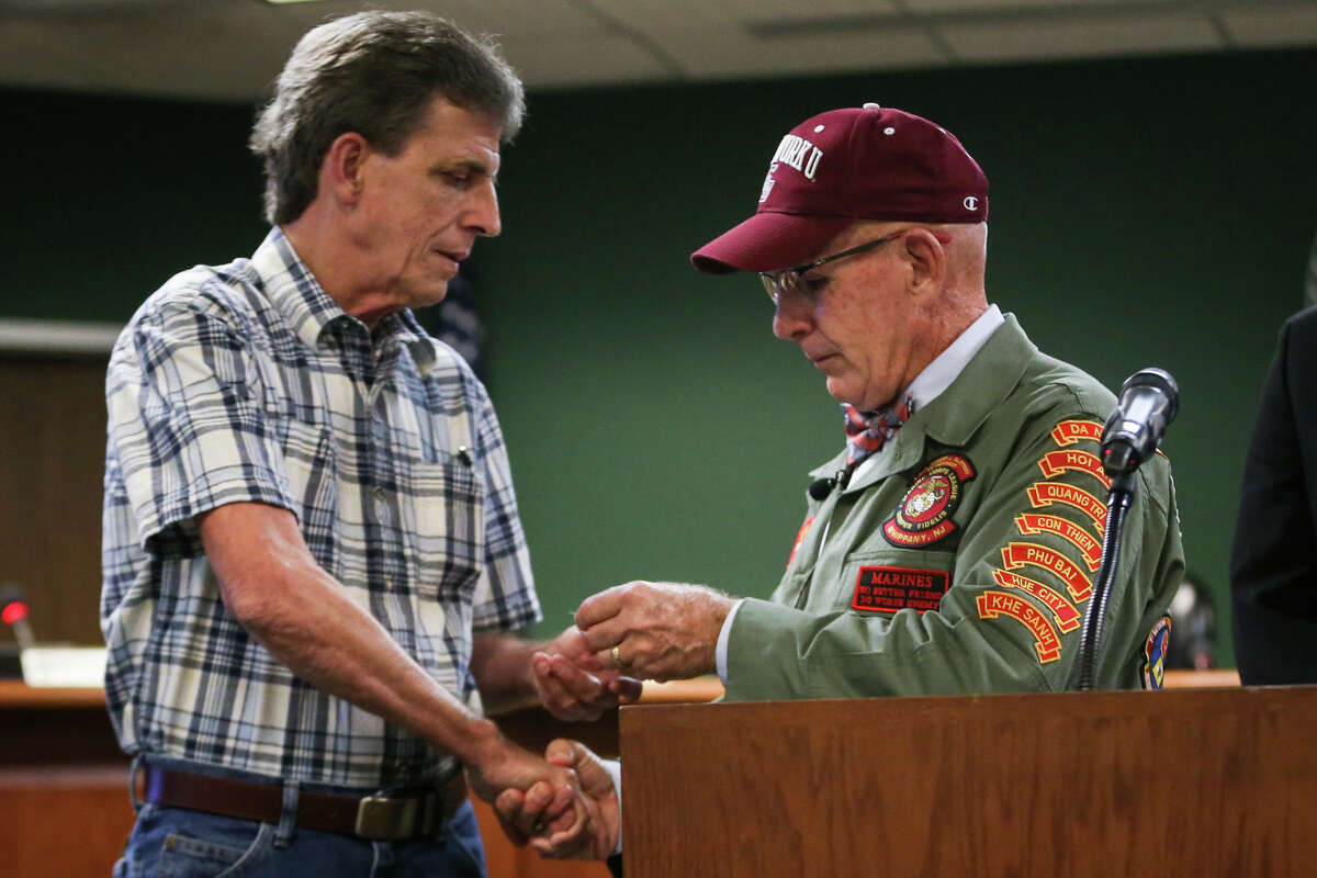 Vietnam Veteran Eddie Neas, right, presents the dog tag of Vietnam Veteran Lance Cpl. David Bruce Freed, who was killed in action, to Freed's brother Magnolia resident Brian Dale Freed, left, during a ceremony on Tuesday, Aug. 8, 2017, at Magnolia City Hall.