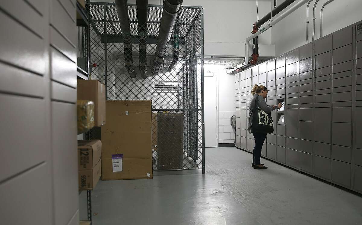 Katie Petrosyan puts a code in the Hub computer to receive her package of books on Wednesday, August 9, 2017, in San Francisco, Calif.. Amazon started Hub, a service where residents of apartment buildings receive packages in on-site lockers.