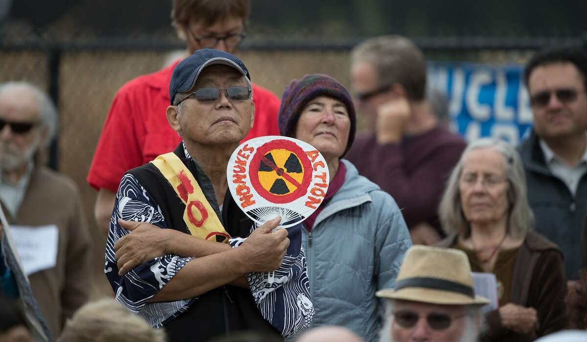 Sam Kano holds a sign at the annual observance of the A-bomb attack on Japan outside the fence of the Lawrence Livermore National Laboratory on Wednesday, Aug. 9, 2017 in Livermore, CA.