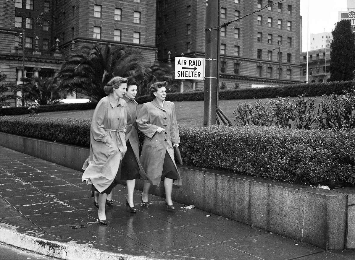 Three women walk toward the Union Square garage during an air raid drill in San Francisco on March 11, 1952.